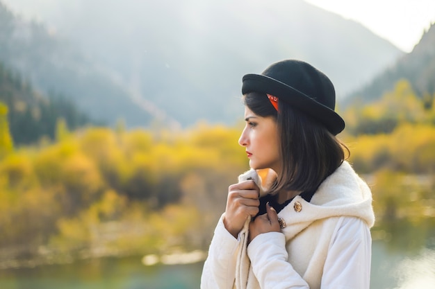 Une jeune femme en blouse blanche marchant dans la nature détourne le regard Se mettre à l'abri du froid d'automne