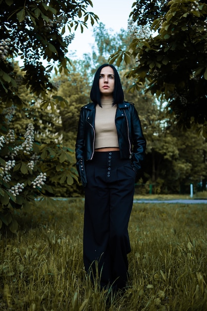 Jeune femme en blouson de cuir au parc