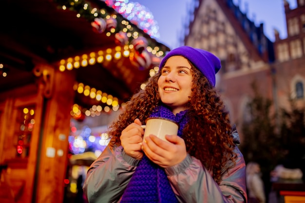 Jeune femme avec boisson sur le marché de Noël à Wroclaw, Pologne