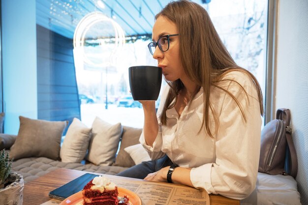 La jeune femme boit du café dans un café