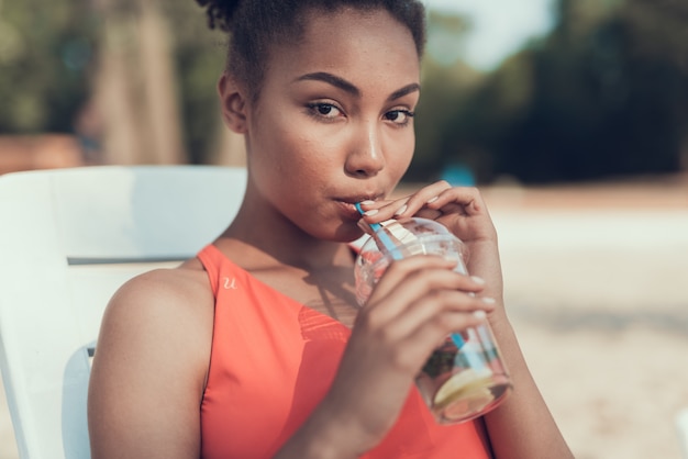 Photo jeune femme boit et se repose sur la rivière