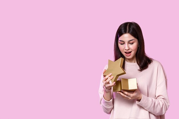 Une jeune femme avec une boîte-cadeau dans ses mains