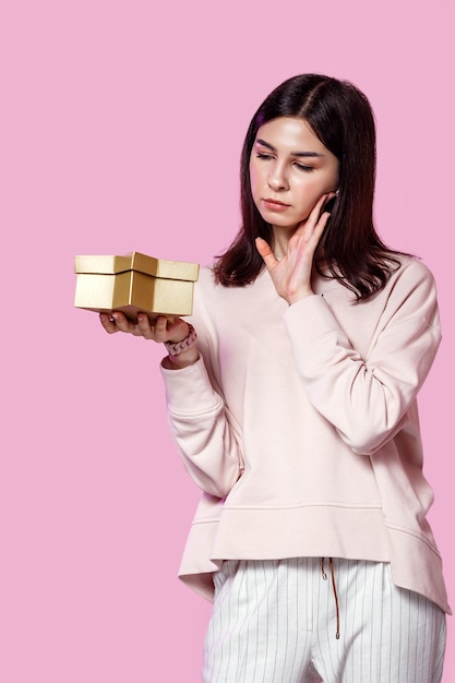 Une jeune femme avec une boîte-cadeau dans ses mains