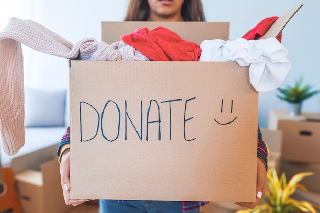 Jeune femme avec une boîte de donation à la maison