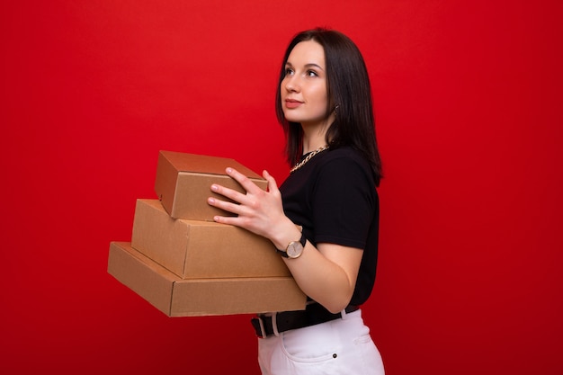 Jeune femme avec des boîtes de papier sur fond rouge