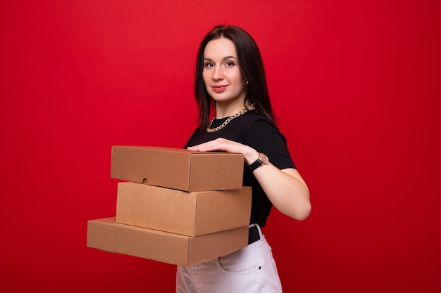 Jeune femme avec des boîtes de papier sur fond rouge