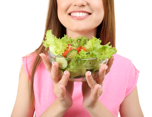 Jeune femme avec bol en verre de salade diététique sur blanc