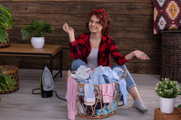 Photo une jeune femme de bonne humeur avant de commencer à repasser des vêtements