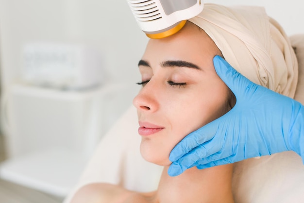 Jeune femme en bonne santé avec une bonne peau faisant des procédures cosmétiques dans une clinique de spa. Femme aux yeux fermés.