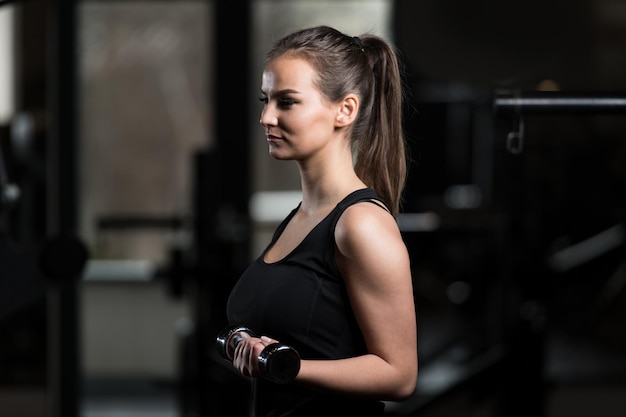 Jeune femme en bonne santé faisant de l'exercice pour les biceps