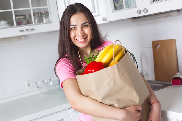 Jeune femme en bonne santé avec des légumes frais dans la cuisine