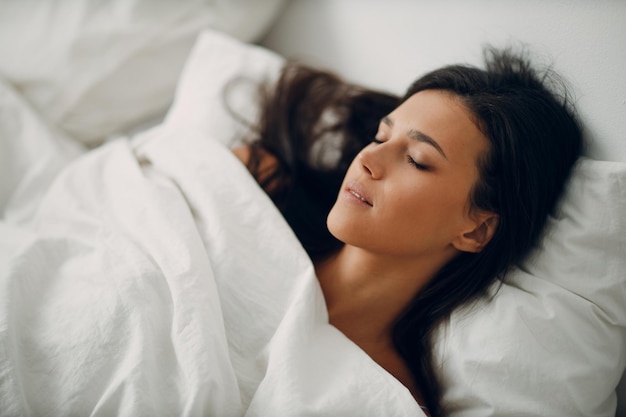 Jeune femme en bonne santé s'habiller nuisette allongée sur le lit dans la chambre