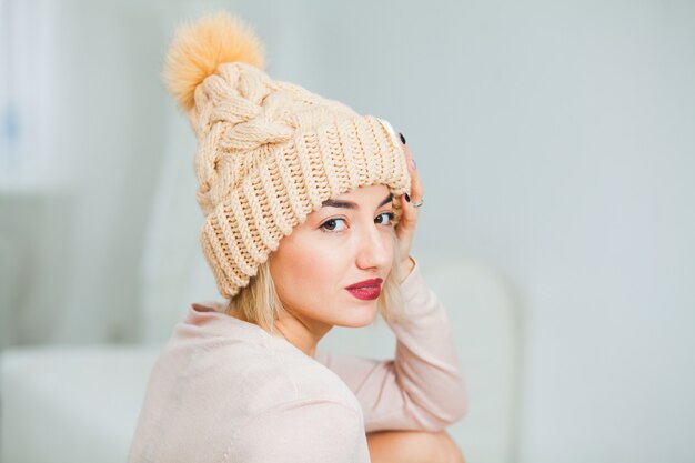 Jeune femme en bonnet tricoté main chaude à la maison