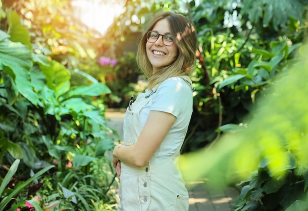 Jeune femme botaniste au travail dans un jardin botanique en journée ensoleillée