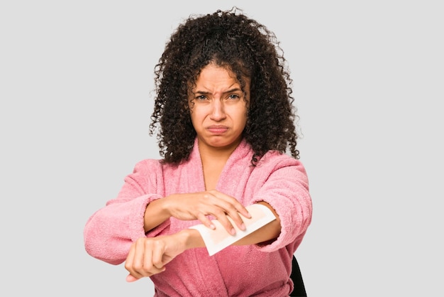 Photo jeune femme bouclée afro-américaine portant un peignoir et une épilation isolée