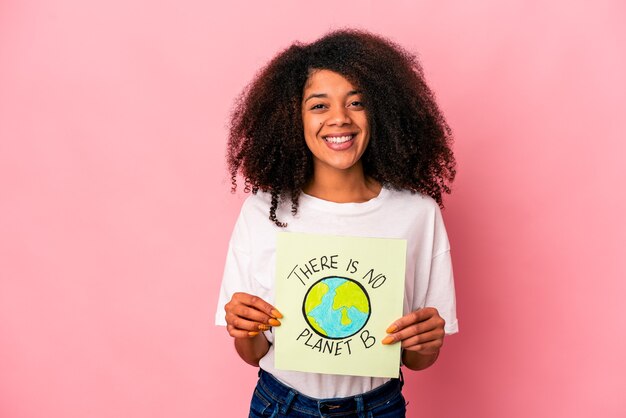 Photo jeune femme bouclée afro-américaine tenant un message de planète sur une pancarte heureuse, souriante et gaie.