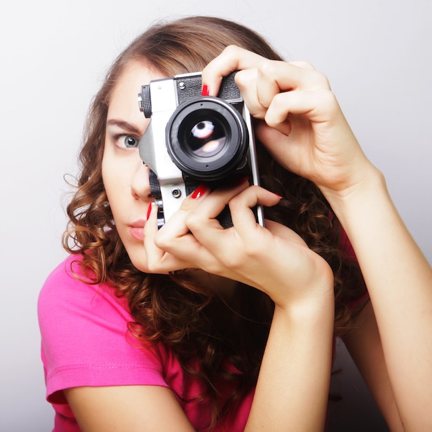 Jeune femme bouclée avec appareil photo vintage