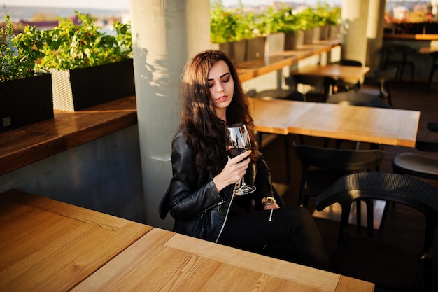 Jeune femme bouclée appréciant son vin dans un bar