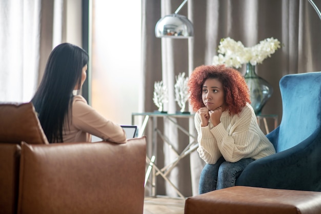 Photo jeune femme bouclée parlant à son psychothérapeute