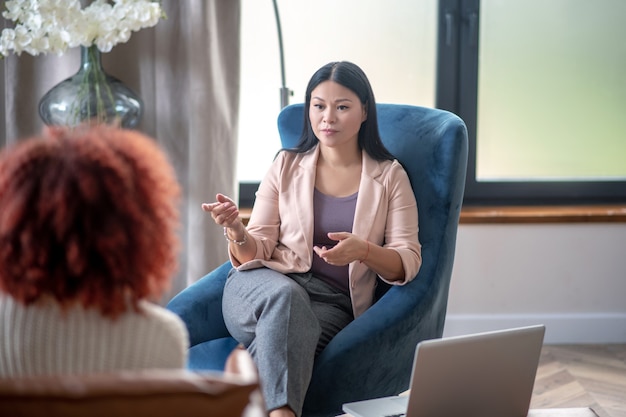 Jeune femme bouclée parlant à son psychothérapeute