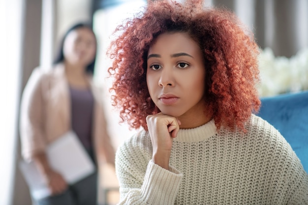 Photo jeune femme bouclée parlant à son psychothérapeute