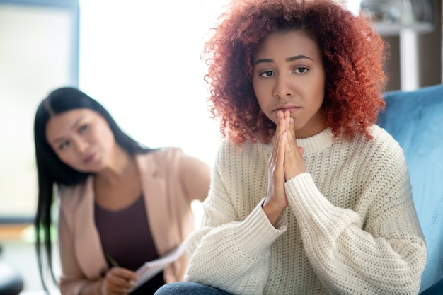 Photo jeune femme bouclée parlant à son psychothérapeute