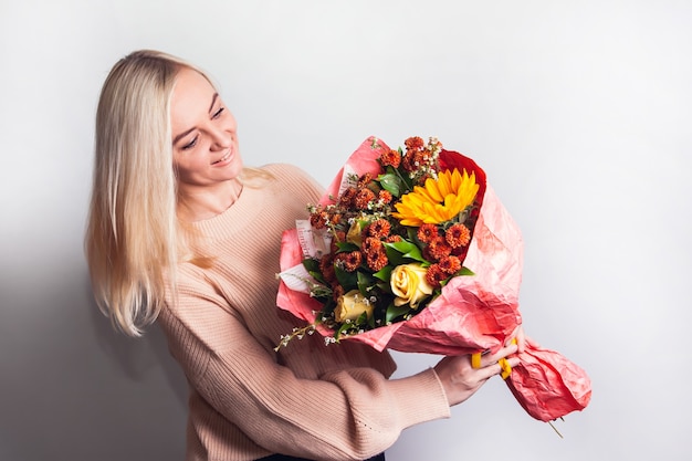 Jeune femme avec un bouquet d'automne avec un tournesol