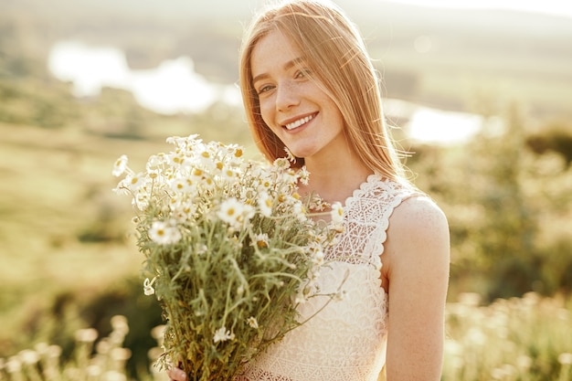 Jeune femme avec bouquet de camomille