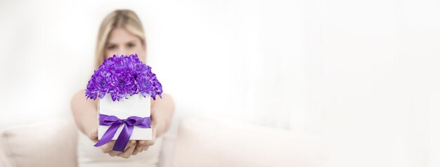 Photo une jeune femme et un bouquet de chrysanthèmes violets