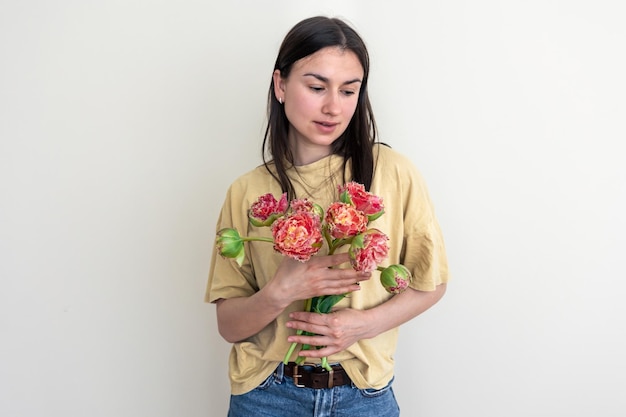 Une jeune femme avec un bouquet de fleurs sur un fond blanc