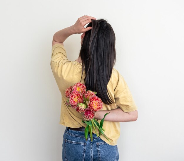 Une jeune femme avec un bouquet de fleurs sur un fond blanc