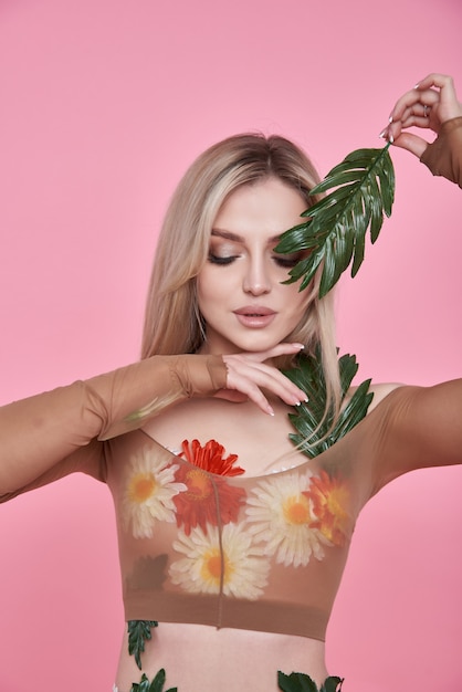 jeune femme avec un bouquet de fleurs de printemps sur fond rose