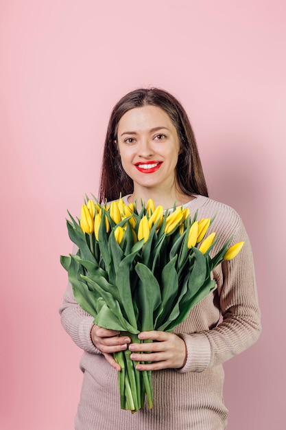 Jeune femme avec bouquet de fleurs de tulipes jaunes