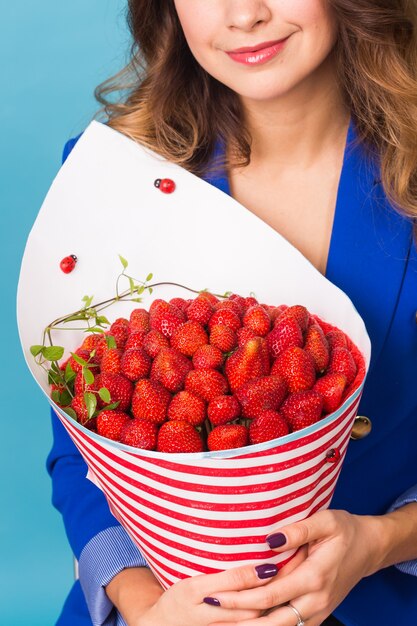 Jeune femme avec un bouquet de fraise