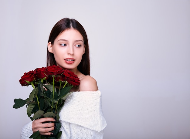 jeune femme avec un bouquet de roses rouges.