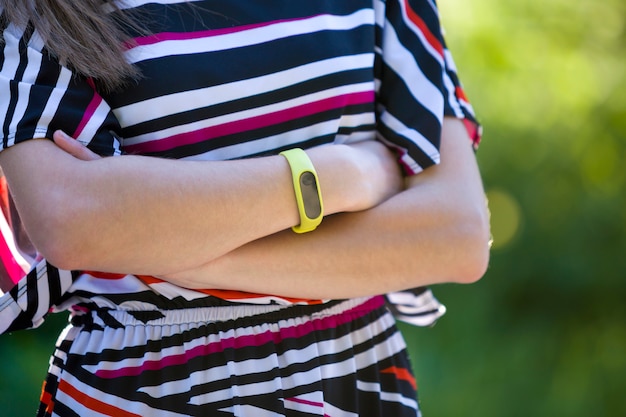 Jeune femme bras avec bracelet de fitness sur l'extérieur floue.