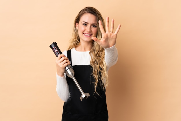 Jeune femme brésilienne à l'aide d'un mélangeur à main