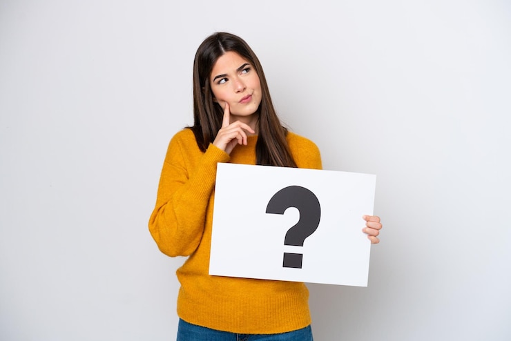 Photo jeune femme brésilienne isolée sur fond blanc tenant une pancarte avec le symbole de point d'interrogation et la pensée