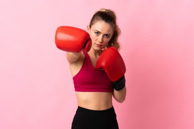 Jeune femme brésilienne isolée sur rose avec des gants de boxe