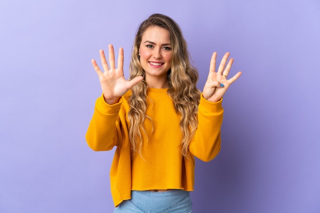 Jeune femme brésilienne isolée sur violet comptant neuf avec les doigts