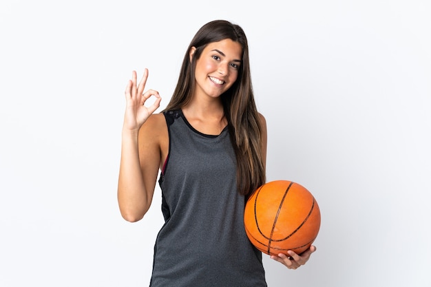 Jeune femme brésilienne jouant au basket isolé sur fond blanc montrant signe ok avec les doigts