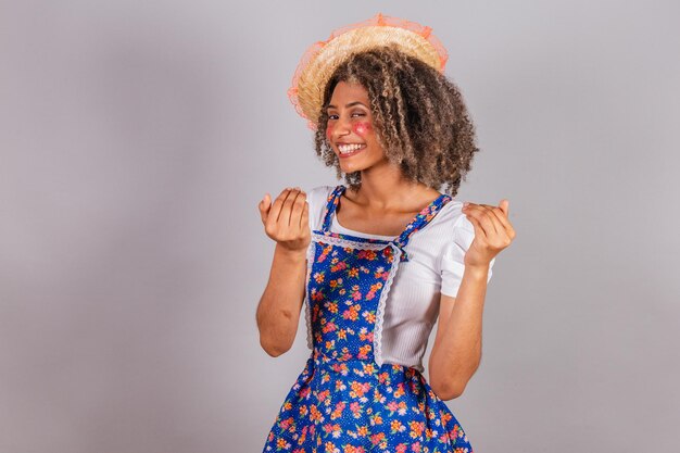 Jeune femme brésilienne noire avec des vêtements de pays habillés pour Festa Junina Saint John's festival appelant avec les mains invitant