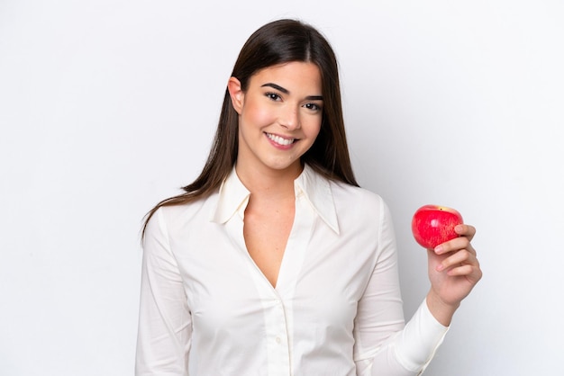 Jeune femme brésilienne avec une pomme isolée sur fond blanc souriant beaucoup