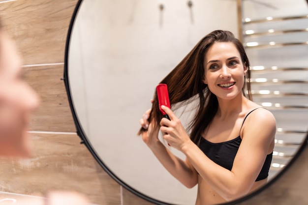 Jeune, femme, brossage, sain, cheveux, devant, miroir, salle bains