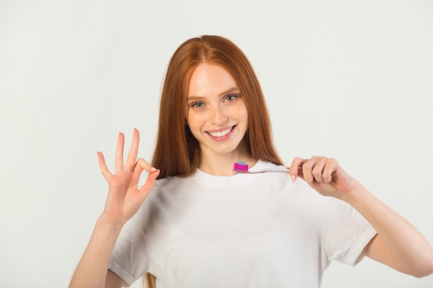 Jeune femme avec une brosse à dents à la main