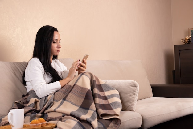 Jeune femme brune à l'aide d'un smartphone