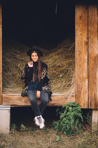 Jeune femme brune assise à la grange Country style