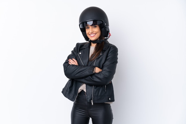 Jeune femme brune avec un casque de moto sur un mur blanc isolé
