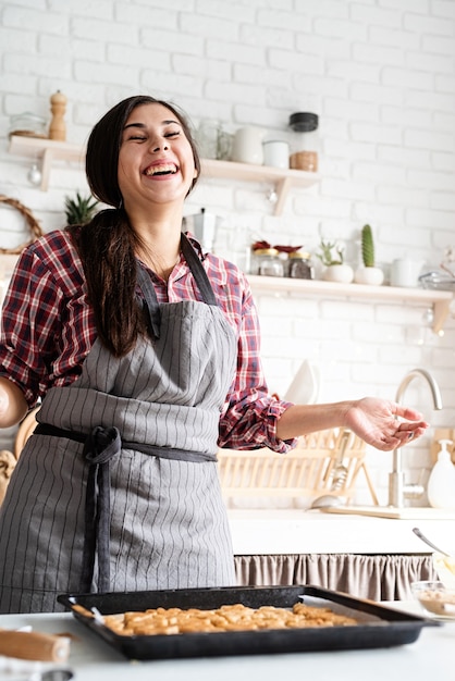 Jeune femme brune, cuisson des cookies dans la cuisine