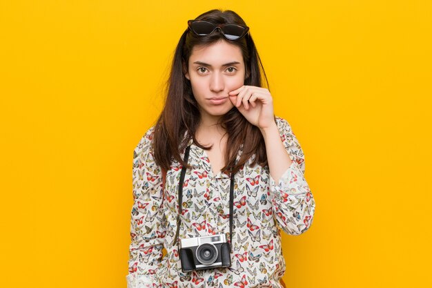 Jeune femme brune avec les doigts sur les lèvres